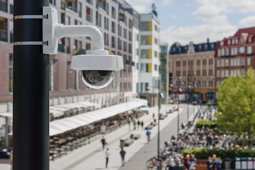 Beveiligingscamera Den Haag: koepelcamera aan een paal boven een winkelstraat met terrassen