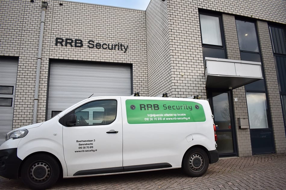Camerabewaking Den Haag: witte servicebus van RRB Security voor een bakstenen bedrijfspand met de tekst RRB Security